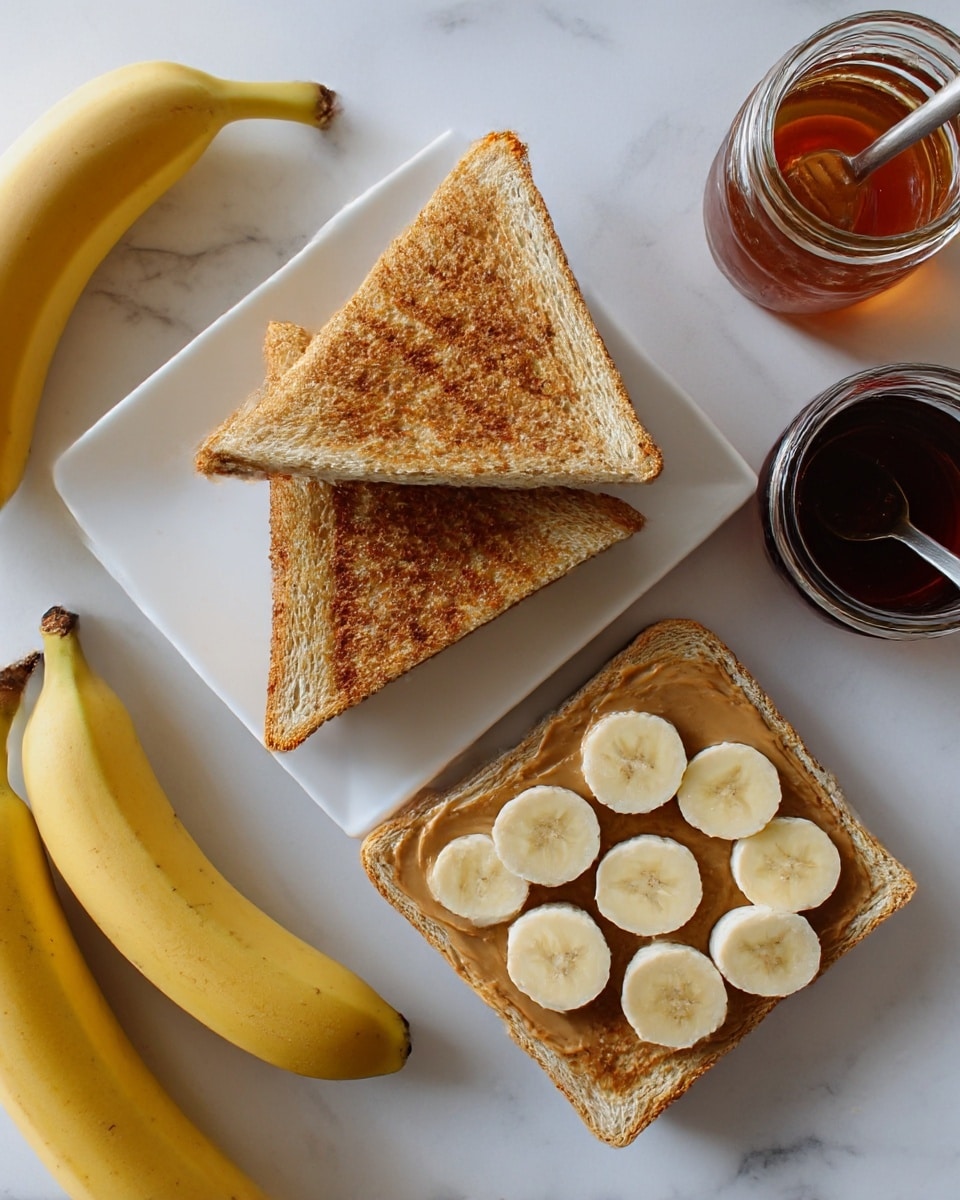 The image shows a white square plate with two triangular grilled sandwiches stacked, one on top and one beside a single slice of toasted bread covered with evenly spread peanut butter and topped with a neat layer of round banana slices. Surrounding the plate on a white marbled surface are two whole yellow bananas, two triangular grilled sandwiches, a small jar of honey, and a jar filled with a dark liquid with a spoon in it. The toasted bread has a golden brown color with a crunchy texture, the peanut butter layer looks creamy light brown, and the banana slices are pale yellow with smooth soft texture. Photo taken with an iphone --ar 4:5 --v 7